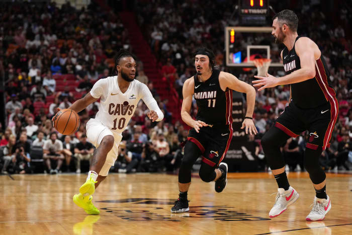 Dec 8, 2023; Miami, Florida, USA; Cleveland Cavaliers guard Darius Garland (10) drives the ball around Miami Heat guard Jaime Jaquez Jr. (11) and forward Kevin Love (42) during the second half at Kaseya Center. Mandatory Credit: Jasen Vinlove-USA TODAY Sports